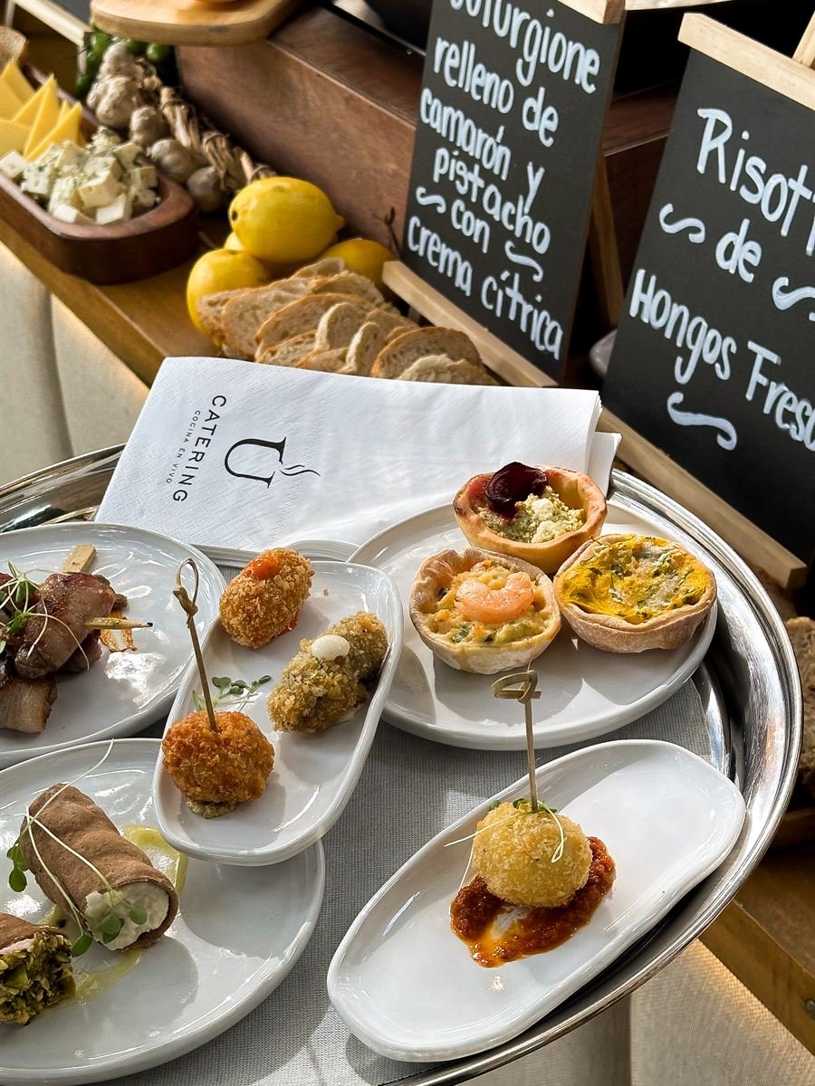Bandeja de plata con entradas y servilleta con el logo de U Catering